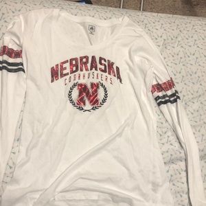 Long sleeve white tee with Nebraska Cornhuskers logo on front, strips on arms.